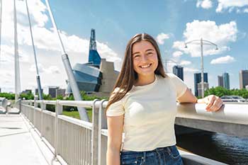 Student standing on a bridge in Winnipeg