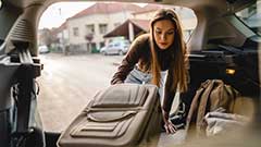 Student packing a car with luggage
