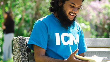 Student reading on a bench outside