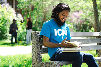 Student sitting on bench with book
