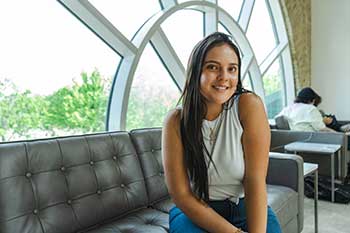 Student sitting on a couch in front of a picture window