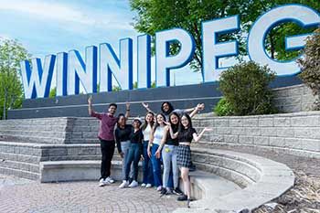 Students in front of the Winnipeg sign