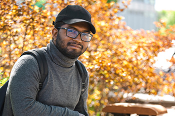 Student with hat sitting on bench