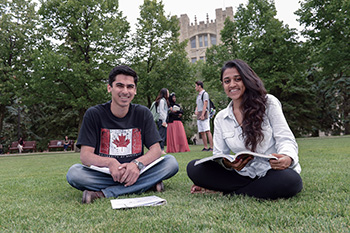 Two students sitting down outside