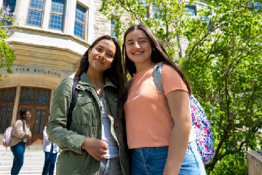 Two students standing together and looking at the camera.