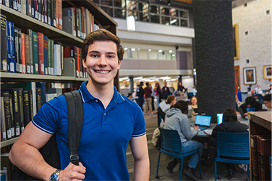 Student at a library smiling at the camera