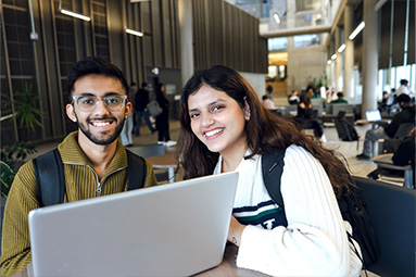 Two students smiling at the camera